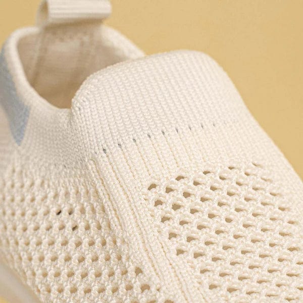 Soft white slip-on baby shoes with cushioned interior